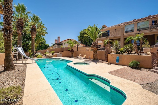 view of swimming pool with an in ground hot tub, a patio area, and a water slide