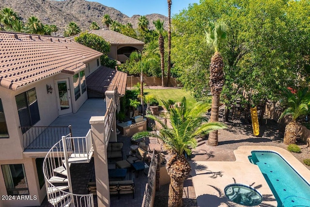 view of swimming pool featuring a patio area, a mountain view, and an in ground hot tub