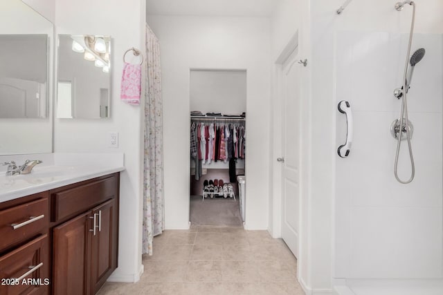 bathroom featuring tile patterned flooring, vanity, and walk in shower