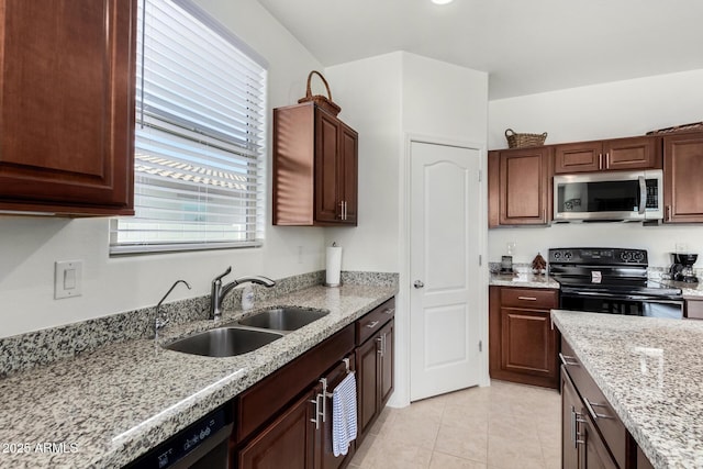 kitchen with light stone counters, light tile patterned flooring, sink, and black appliances