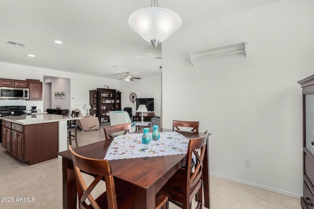 tiled dining space featuring ceiling fan