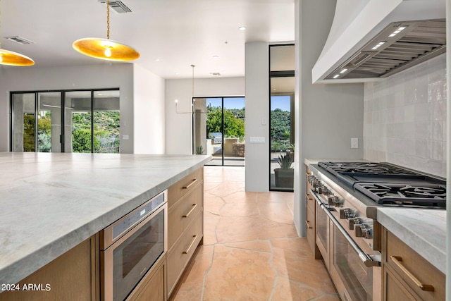 kitchen featuring light tile floors, decorative light fixtures, custom exhaust hood, appliances with stainless steel finishes, and backsplash