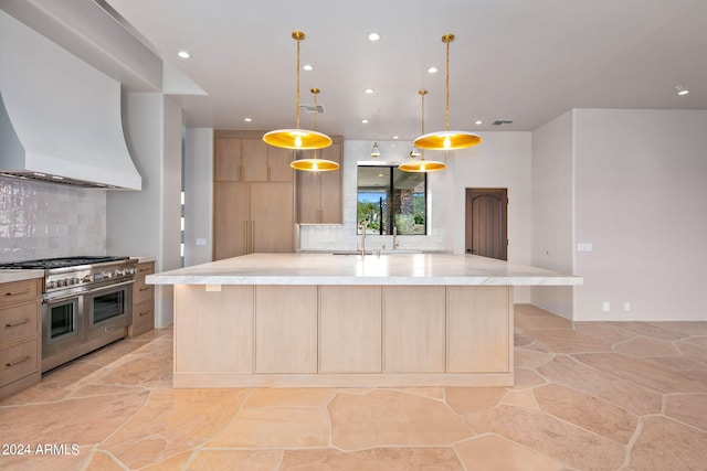 kitchen with a kitchen island with sink, backsplash, range with two ovens, and decorative light fixtures