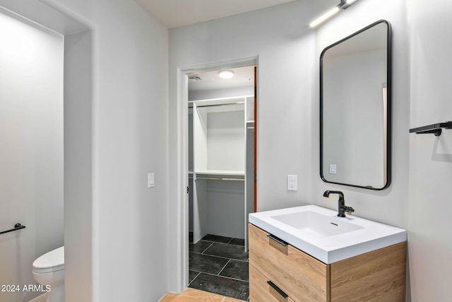 bathroom featuring tile floors, toilet, and vanity