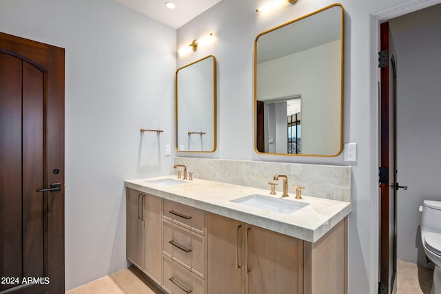 bathroom with double sink vanity, tile floors, and toilet