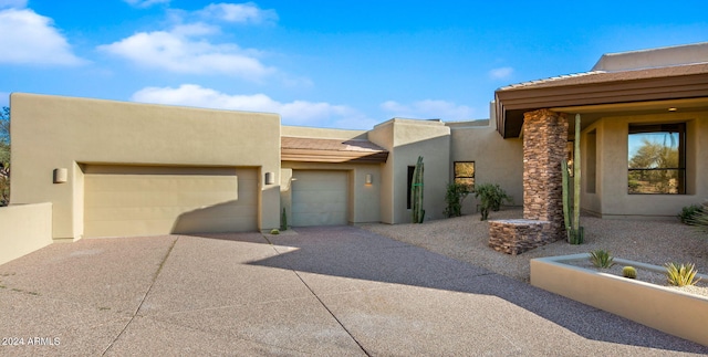 pueblo-style house featuring a garage