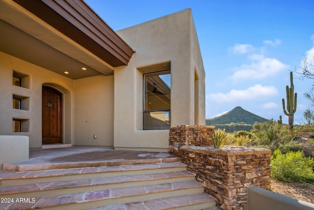 doorway to property featuring a mountain view and a patio