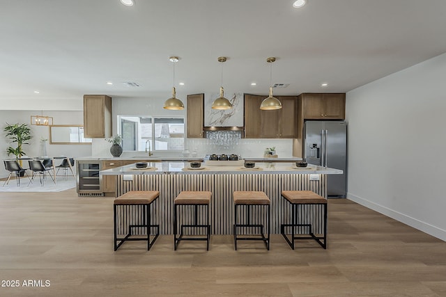 5028 W Shangri La Rd, Glendale, AZ 85304 - kitchen with stainless steel refrigerator with ice dispenser, beverage cooler, a breakfast bar area, a kitchen island, and light countertops