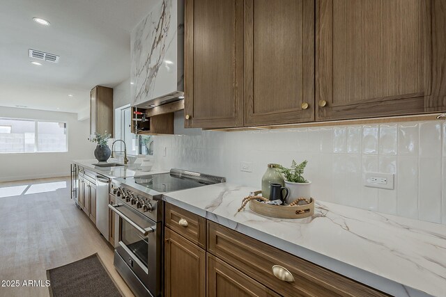5028 W Shangri La Rd, Glendale, AZ 85304 - kitchen with appliances with stainless steel finishes, tasteful backsplash, light wood-style floors, light stone counters, and recessed lighting