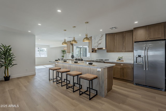 5028 W Shangri La Rd, Glendale, AZ 85304 - kitchen with stainless steel refrigerator with ice dispenser, a breakfast bar, light wood-type flooring, custom range hood, and recessed lighting