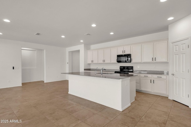 kitchen featuring recessed lighting, a kitchen island with sink, a sink, and black appliances