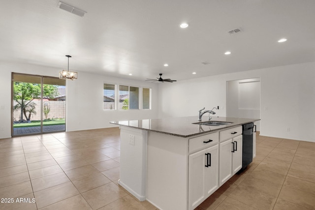 kitchen featuring open floor plan, dark stone counters, a sink, and visible vents