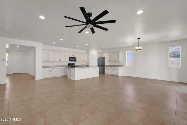 unfurnished living room with ceiling fan with notable chandelier, light tile patterned floors, visible vents, and recessed lighting