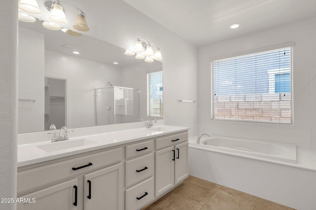 bathroom with a shower stall, tile patterned floors, double vanity, and a sink