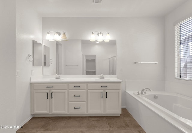 full bath with a sink, visible vents, a bath, and double vanity