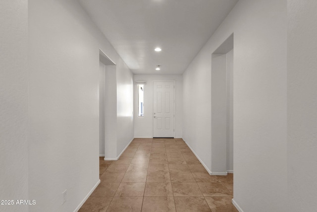 corridor featuring light tile patterned floors, baseboards, and recessed lighting