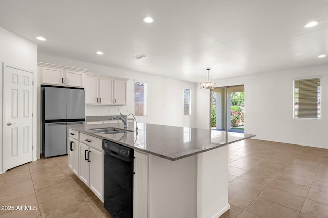 kitchen with dishwasher, a sink, freestanding refrigerator, light tile patterned flooring, and stone countertops
