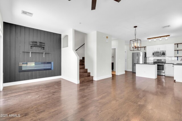 1350 S Greenfield Rd Unit 1166, Mesa, AZ 85206 - unfurnished living room featuring stairs, ceiling fan, a chandelier, dark wood-style floors, and baseboards