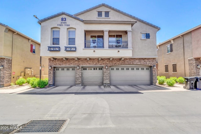 1350 S Greenfield Rd Unit 1166, Mesa, AZ 85206 - townhome / multi-family property featuring stucco siding, an attached garage, driveway, and stone siding