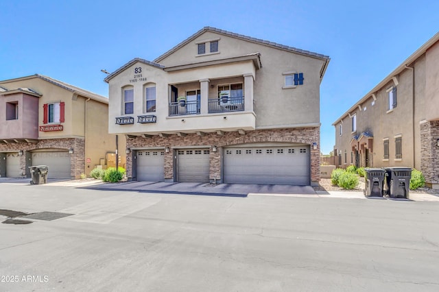 1350 S Greenfield Rd Unit 1166, Mesa, AZ 85206 - view of property with an attached garage, stone siding, stucco siding, and a balcony