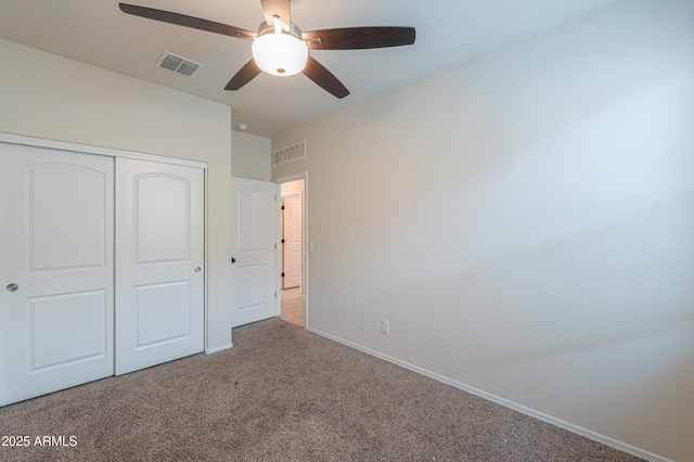 unfurnished bedroom featuring light carpet, a closet, and ceiling fan