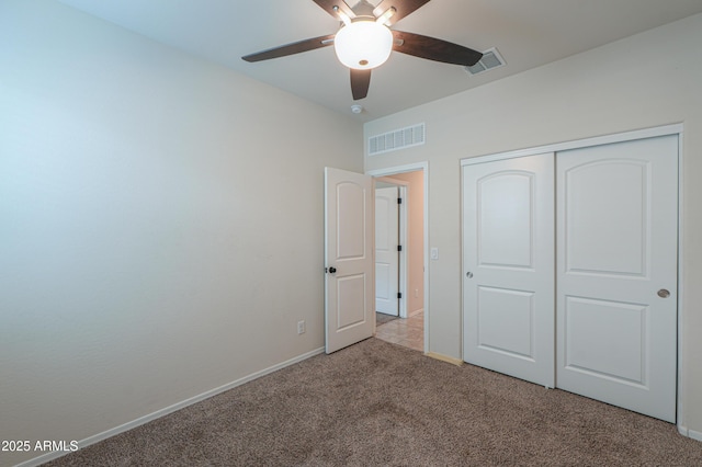 unfurnished bedroom with ceiling fan, a closet, and light carpet