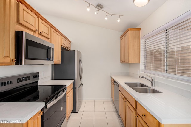 kitchen with appliances with stainless steel finishes, light brown cabinets, light tile patterned floors, and sink