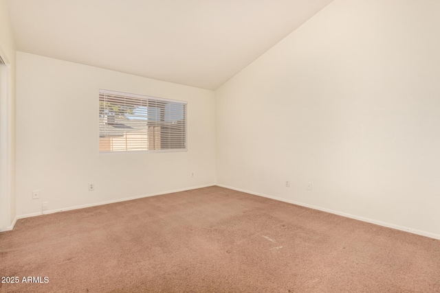 unfurnished room featuring lofted ceiling and carpet floors