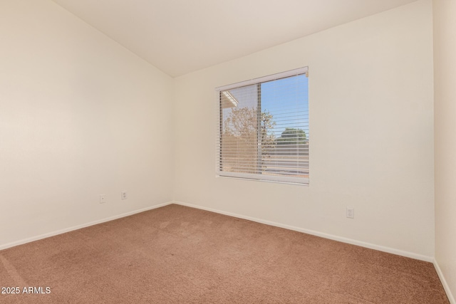 empty room featuring carpet and vaulted ceiling