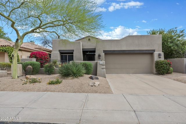 8235 E Sierra Pinta Dr, Scottsdale, AZ 85255 - pueblo revival-style home with a fenced front yard, an attached garage, driveway, and stucco siding