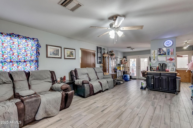 living room with light wood-type flooring, ceiling fan, and french doors