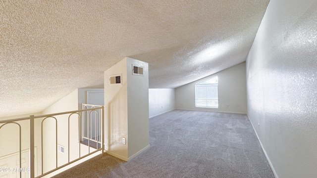 bonus room featuring lofted ceiling, carpet flooring, and a textured ceiling