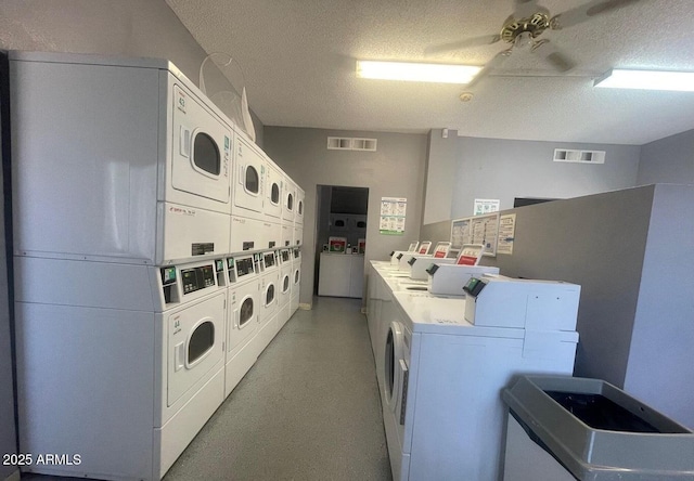 laundry area with stacked washer / drying machine, washer and clothes dryer, and a textured ceiling