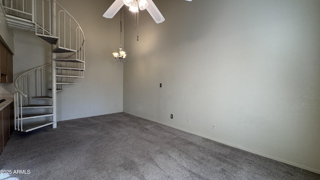 unfurnished living room with carpet flooring and ceiling fan with notable chandelier