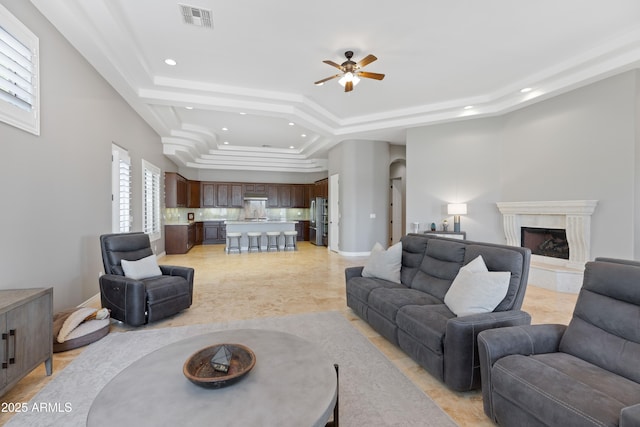 16246 E Gamble Ln, Scottsdale, AZ 85262 - living area with a tray ceiling, recessed lighting, ceiling fan, plenty of natural light, and a premium fireplace