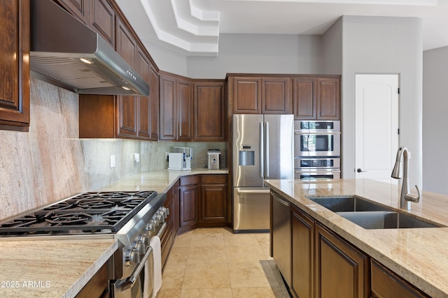16246 E Gamble Ln, Scottsdale, AZ 85262 - kitchen with under cabinet range hood, stainless steel appliances, tasteful backsplash, light stone counters, and light tile patterned floors