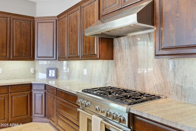 16246 E Gamble Ln, Scottsdale, AZ 85262 - kitchen with stainless steel stove, under cabinet range hood, tasteful backsplash, and light stone countertops