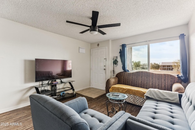 living area featuring a textured ceiling, ceiling fan, dark wood-style flooring, and baseboards