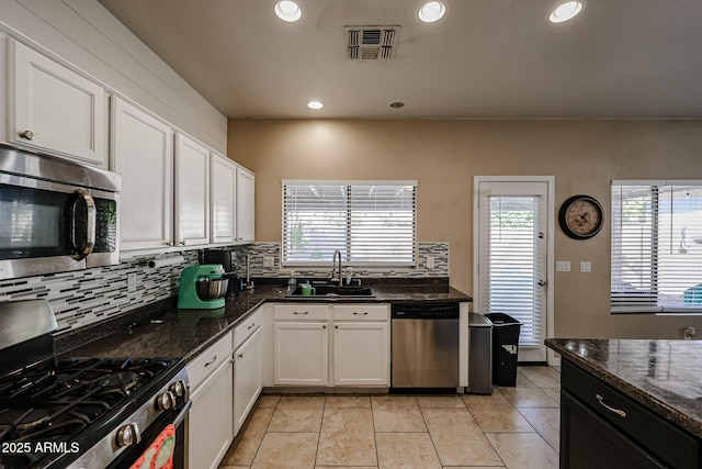 6640 W Honeysuckle Dr, Phoenix, AZ 85083 - kitchen featuring sink, appliances with stainless steel finishes, white cabinetry, dark stone countertops, and decorative backsplash