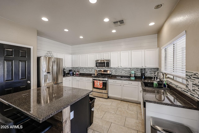 6640 W Honeysuckle Dr, Phoenix, AZ 85083 - kitchen with sink, dark stone countertops, a kitchen island, stainless steel appliances, and white cabinets
