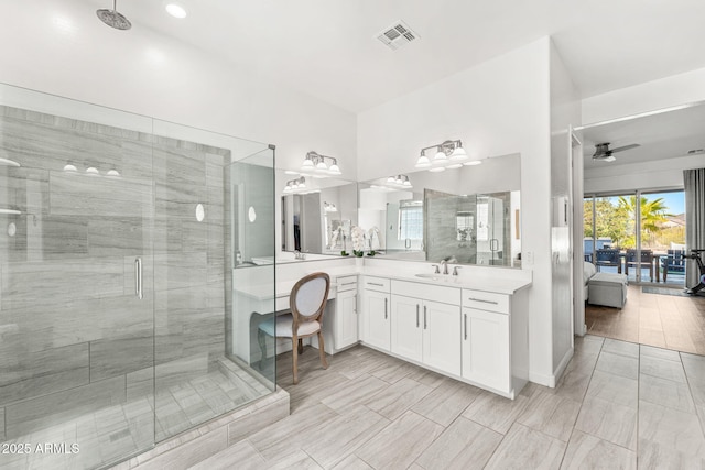 bathroom featuring visible vents, a ceiling fan, a stall shower, and vanity