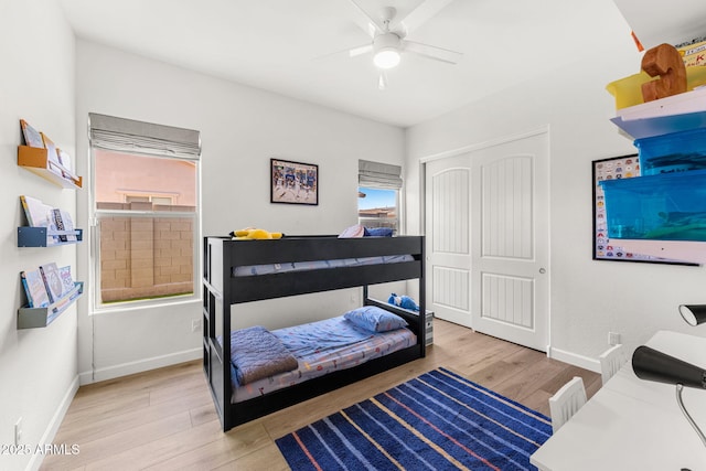 bedroom with wood finished floors, a closet, and baseboards