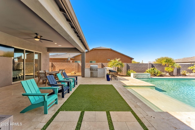 view of pool with grilling area, an outdoor kitchen, a patio, and a fenced backyard