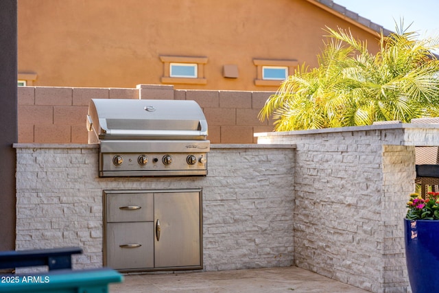 view of patio with area for grilling and a grill