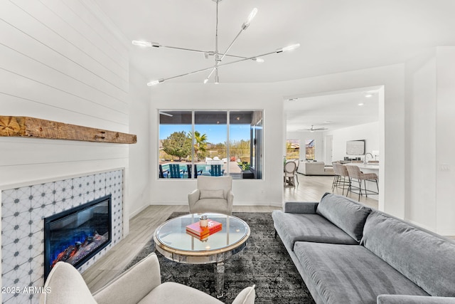 living area with a tiled fireplace and wood finished floors