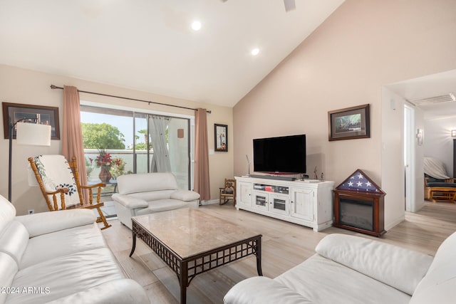 living room featuring light hardwood / wood-style floors and high vaulted ceiling