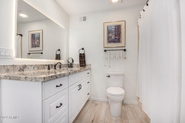 bathroom featuring vanity, toilet, hardwood / wood-style flooring, and a shower with curtain