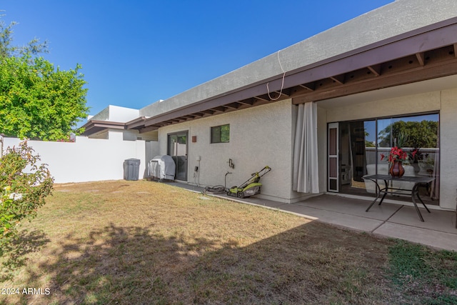 back of property featuring a patio and a yard