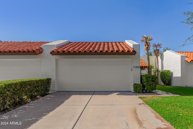 view of front of property with a front yard and a garage