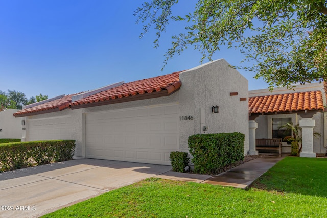 view of front of house featuring a garage and a front lawn